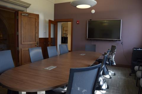 Conference Room with a large oval table, large screen on the wall, maximum capacity of 20